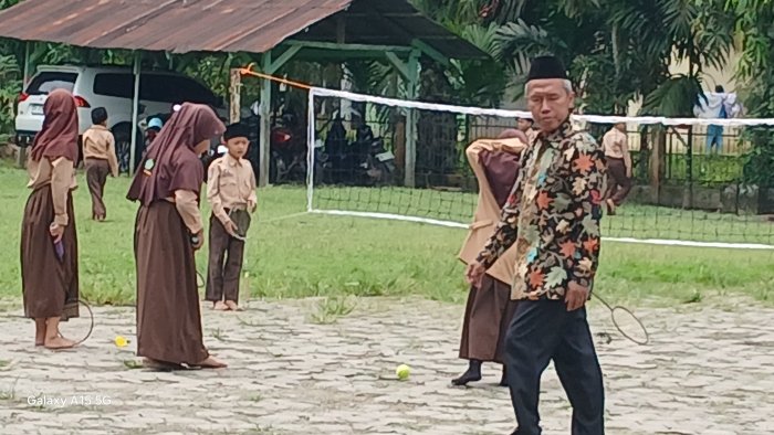 Guru Aktif Dampingi Siswa Belajar di Halaman Madrasah Guru Aktif Dampingi Siswa Belajar di Halaman Madrasah